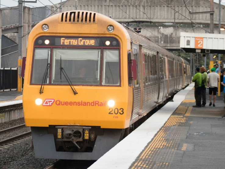 a group of people standing near the train on a track