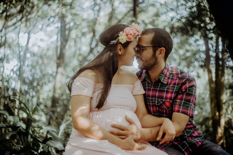 a couple hugging each other in the forest