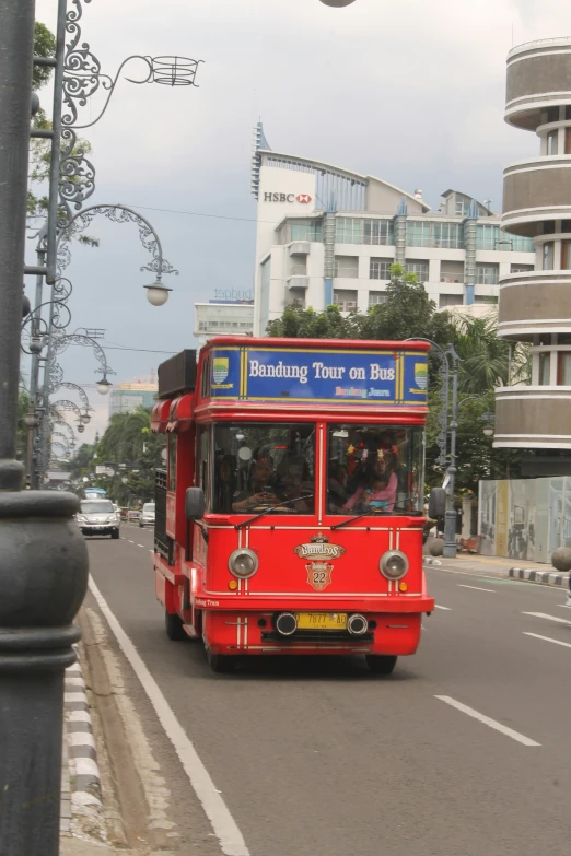 a red bus driving down a street with people on it