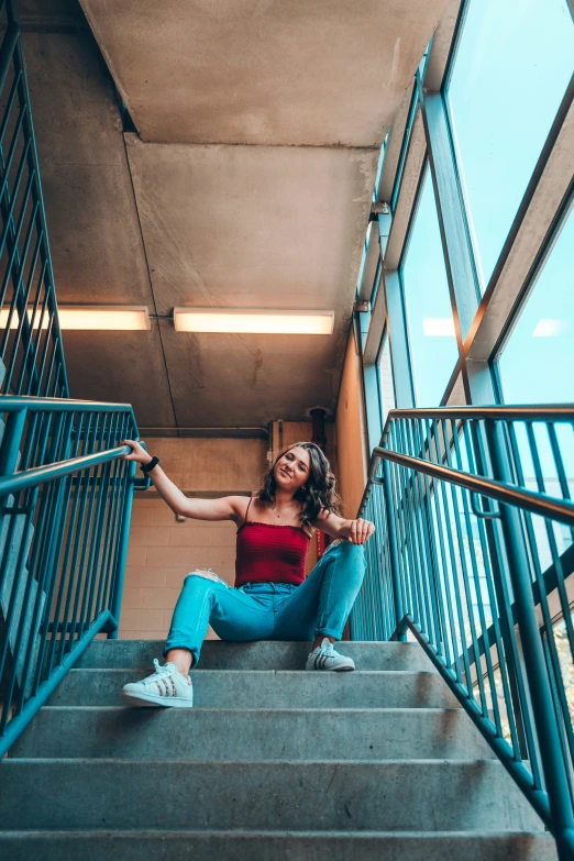 a woman sitting on some stairs posing for a po