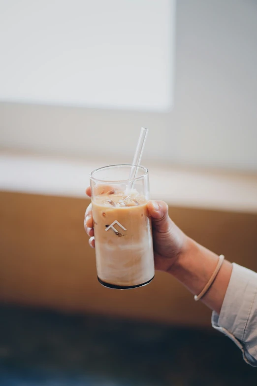 a person holding a tall glass filled with ice cream