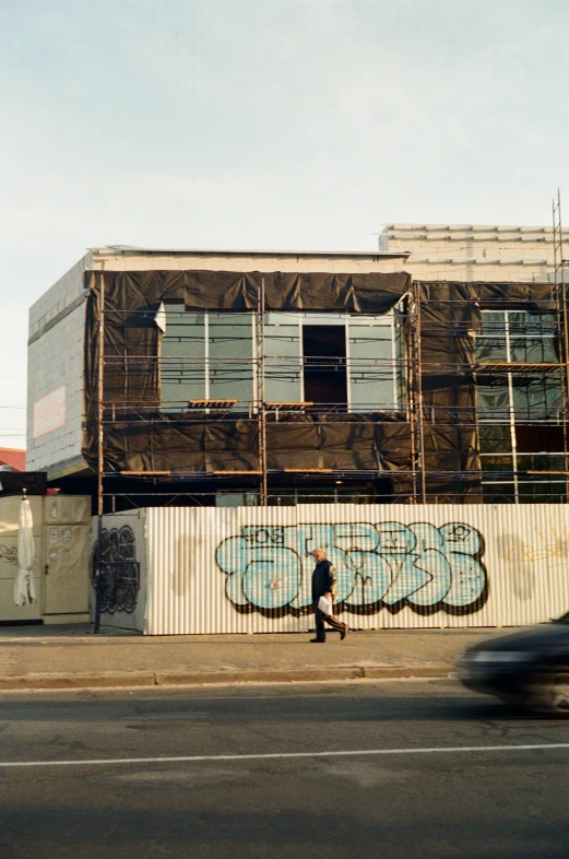 a car driving by a building that has graffiti on it