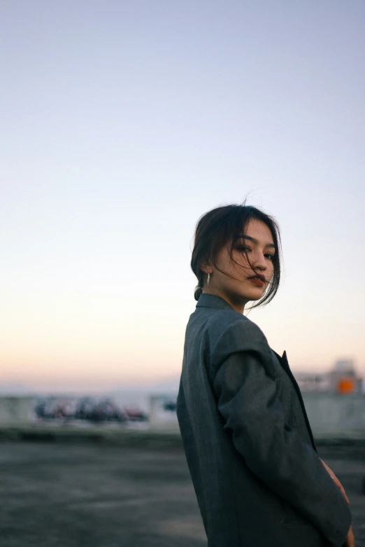 a woman standing on the road in front of the sky