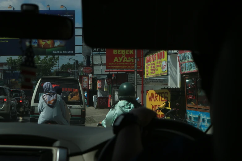 a view from the drivers seat of a taxi as pedestrians walk by on a city street