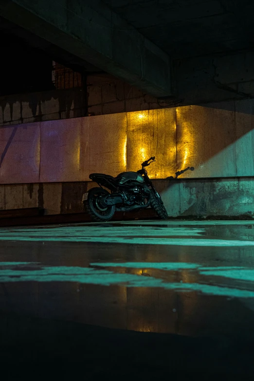 a black motorcycle is parked under a bridge