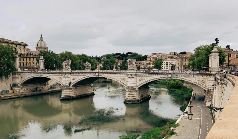 a bridge over water with people standing on the side