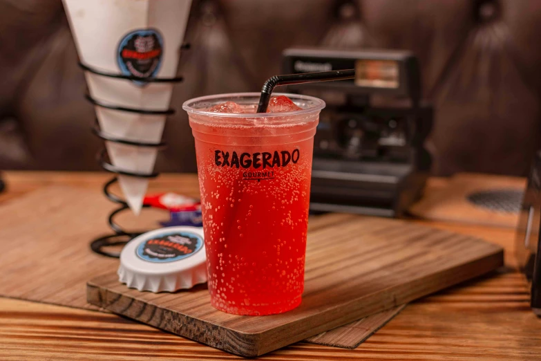 a beverage sits on the coaster next to an old model cell phone