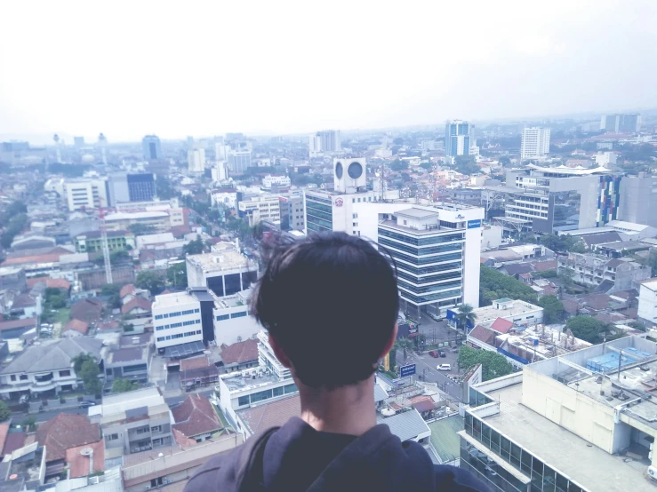 a man looking down at the city skyline