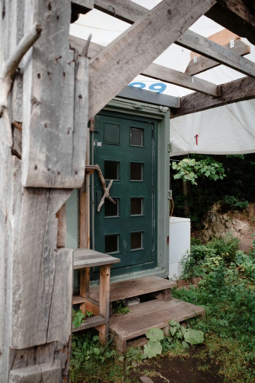 a wooden door is opened to a porch with steps