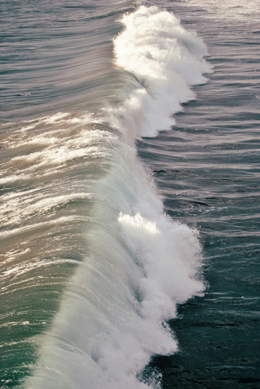 waves roll in and come up against the beach wall