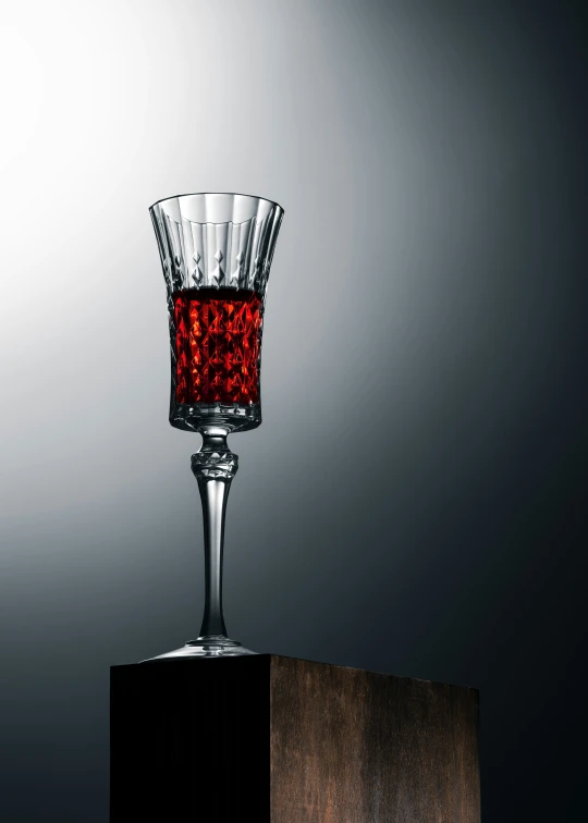 a crystal wine glass with some wine inside it