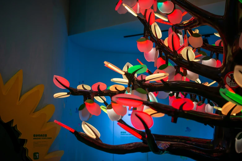 an artistic tree with colorful lights hanging down from it