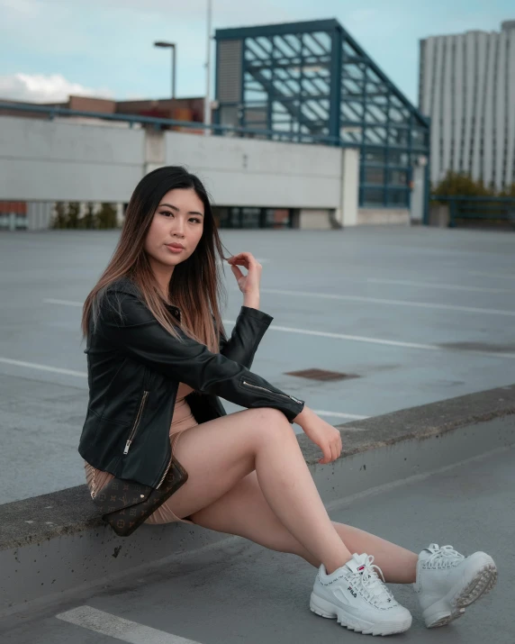 a woman sitting on a ledge in a parking lot