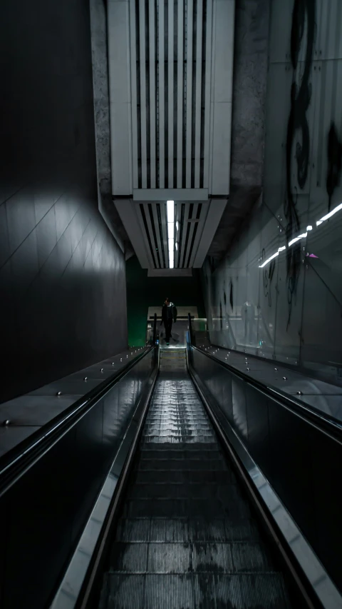 two people walking through an empty subway tunnel