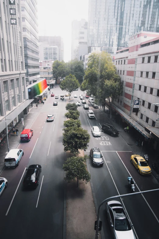 a street lined with buildings next to traffic and trees