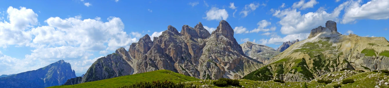 a bunch of green mountains under blue sky