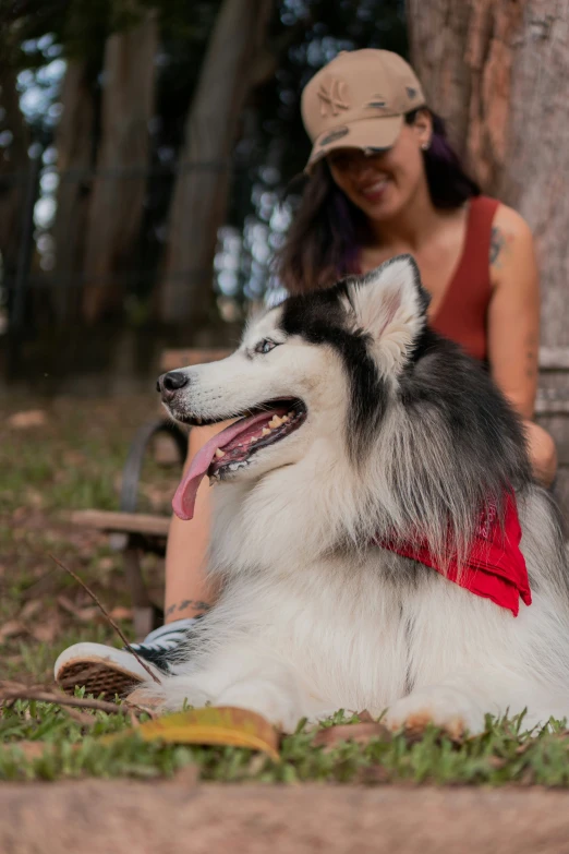 the woman is petting her dog under a tree