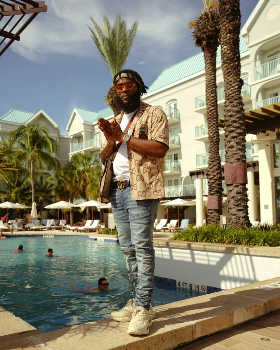 a man stands next to an outdoor pool in front of els