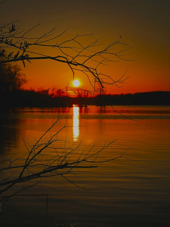 the sunset on the lake is bright orange