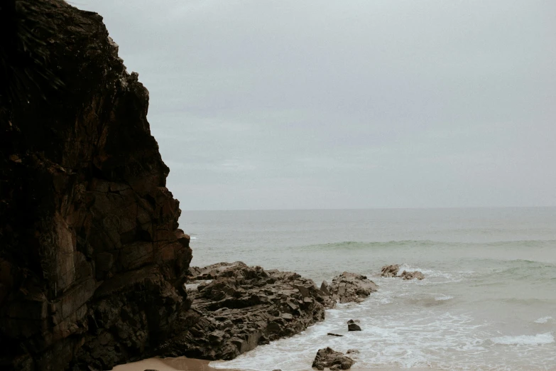 the ocean is crashing onto a rocky shoreline