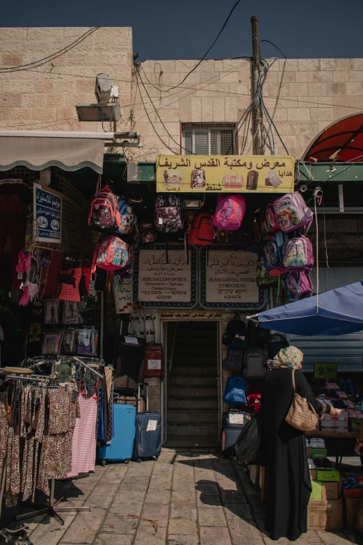 a woman in an arab clothing store looks at items for sale