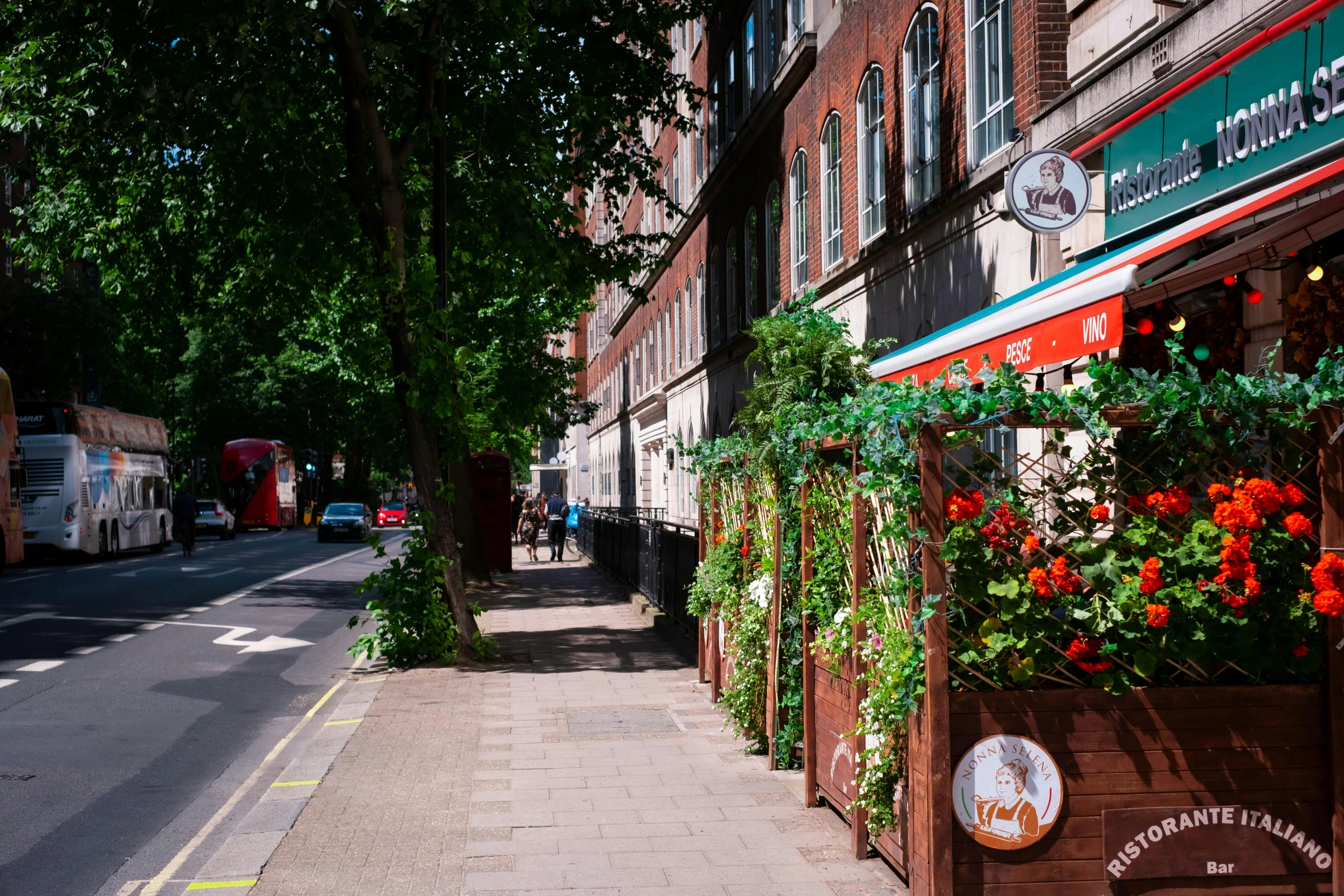 the narrow sidewalk is lined with flower boxes