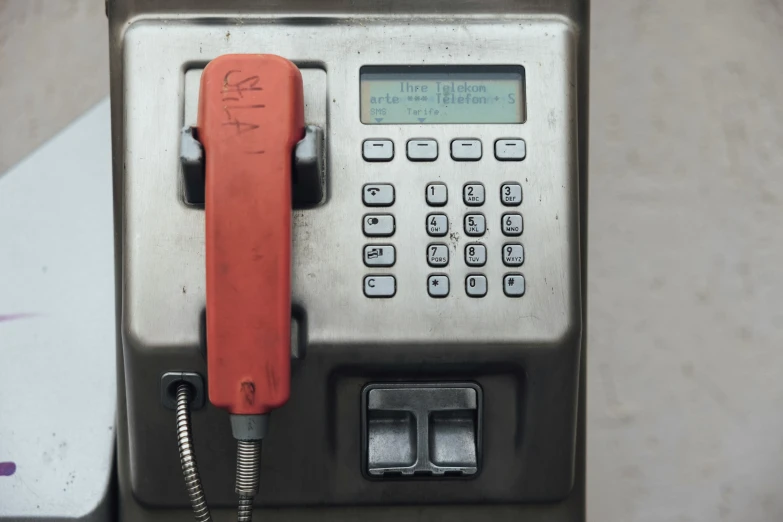 a pay phone in a metal box that is open