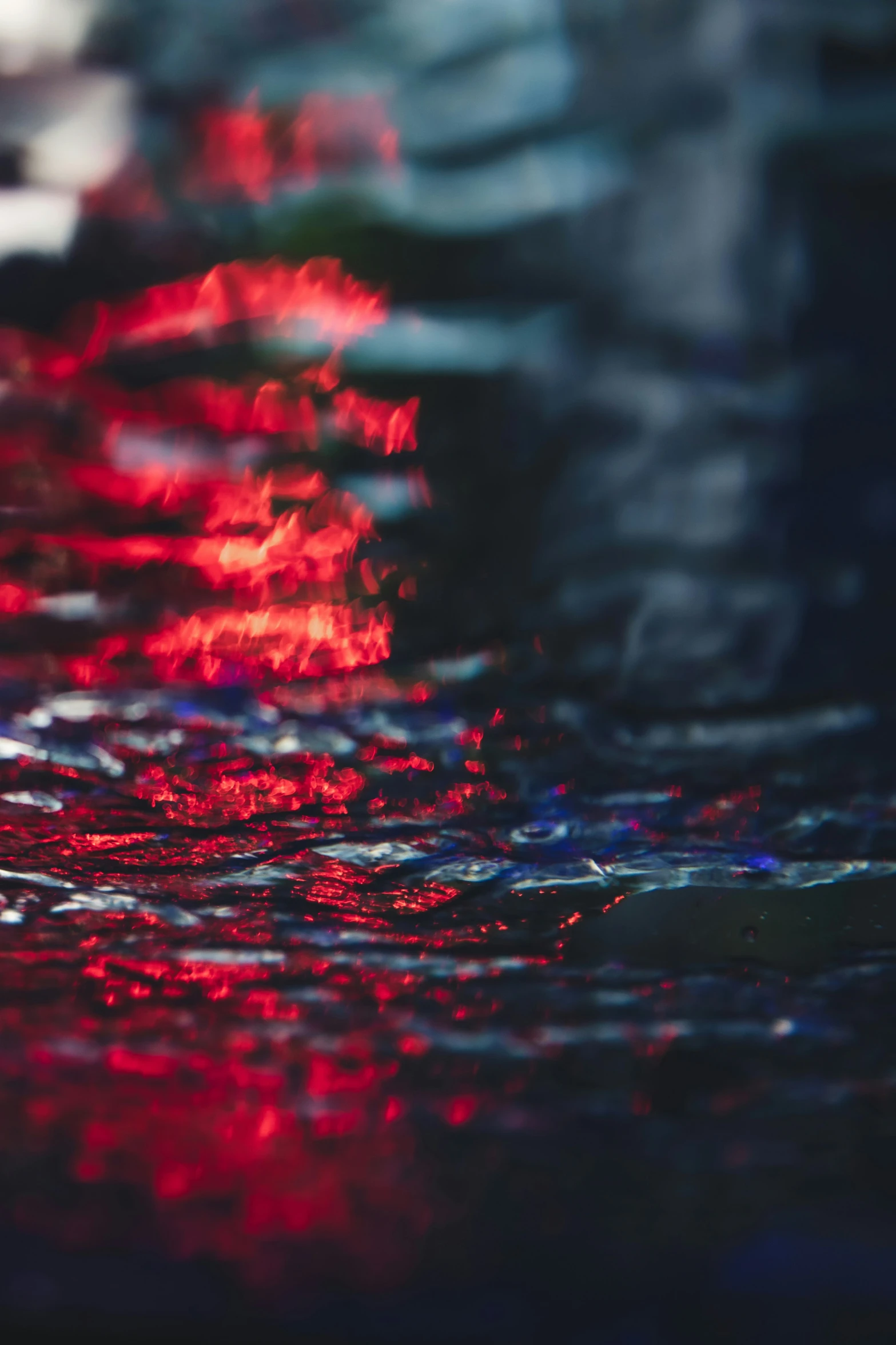 several red and blue reflections of cars in water