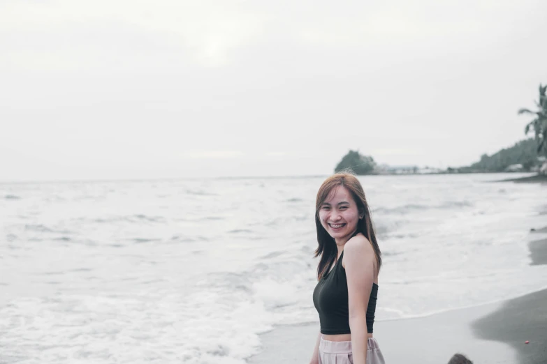 a woman is posing for a po on the beach