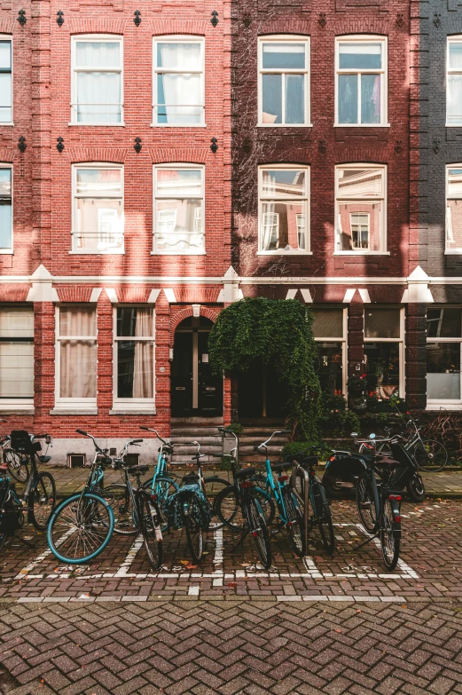 a group of bicycles and bikes sitting on the sidewalk near building