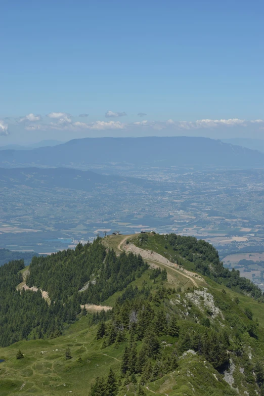 a scenic view of a large hill with a small valley in the distance