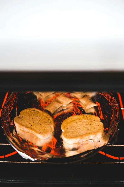 two hamburgers cooking in the oven for dinner