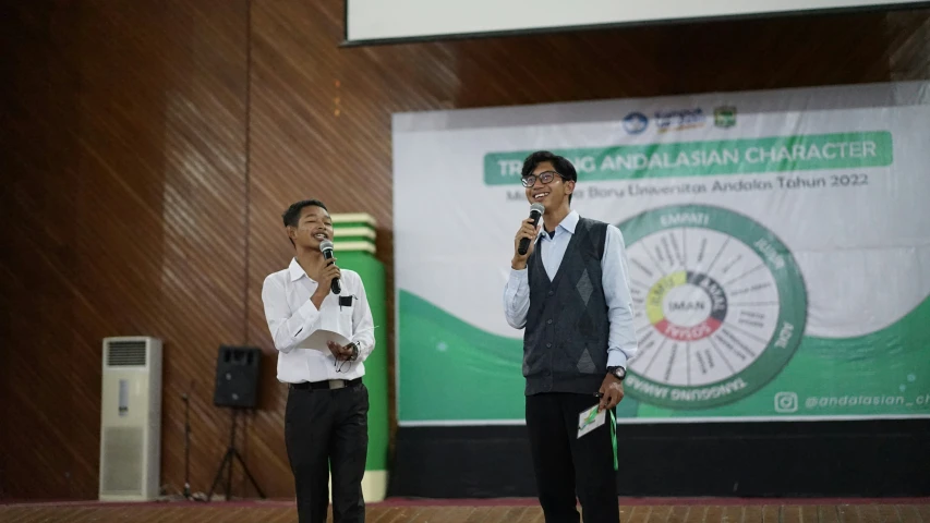 two men standing next to each other while holding microphones