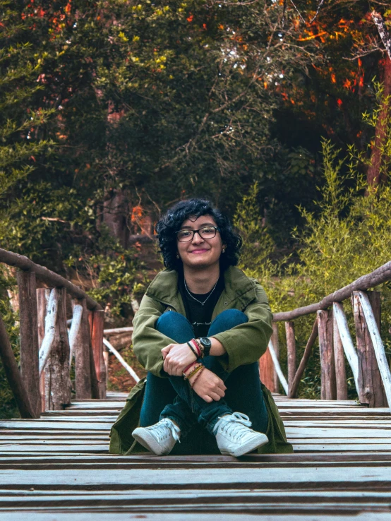 a woman is sitting down on a boardwalk