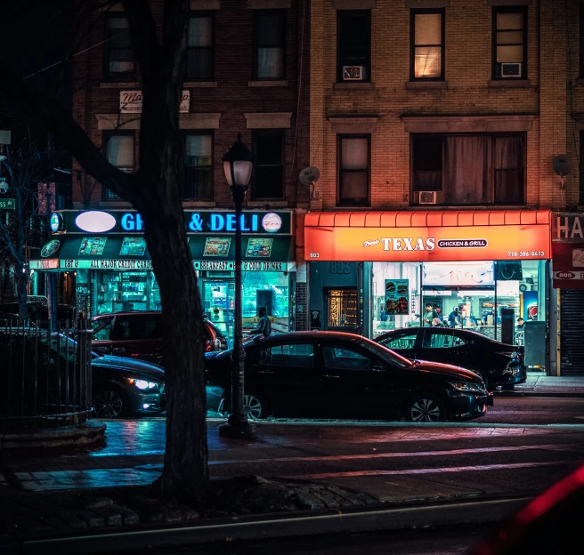 a city street at night with a bunch of neon signs