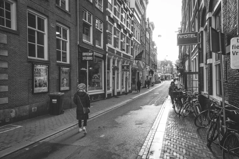 a black and white po of an older woman walking in the middle of the road