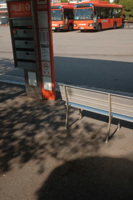 there are two park benches in front of the bus stop