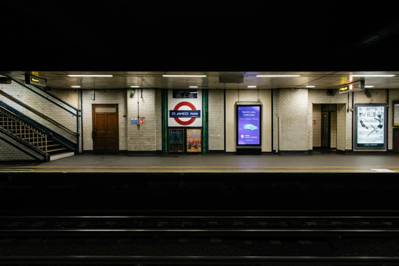 an empty train station at night with stairs and a staircase