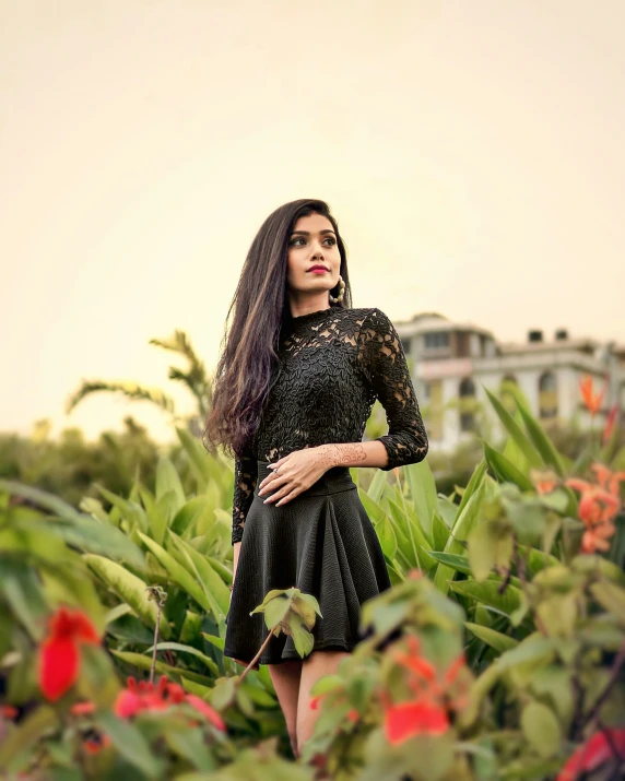 the woman with long hair is standing in front of some plants