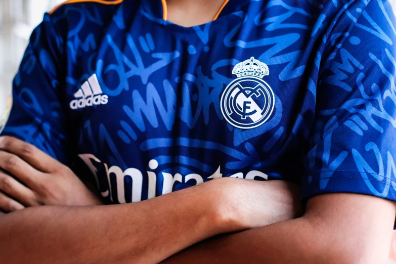 a man in a soccer uniform with his arms folded