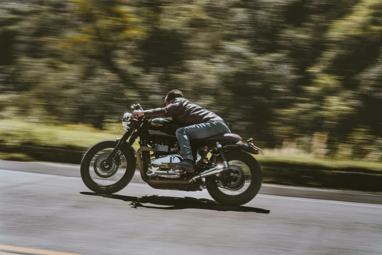 a man on a motorcycle rides on the road