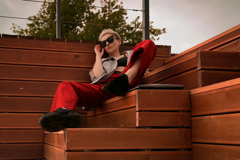 a person sitting on some brown benches talking on the phone