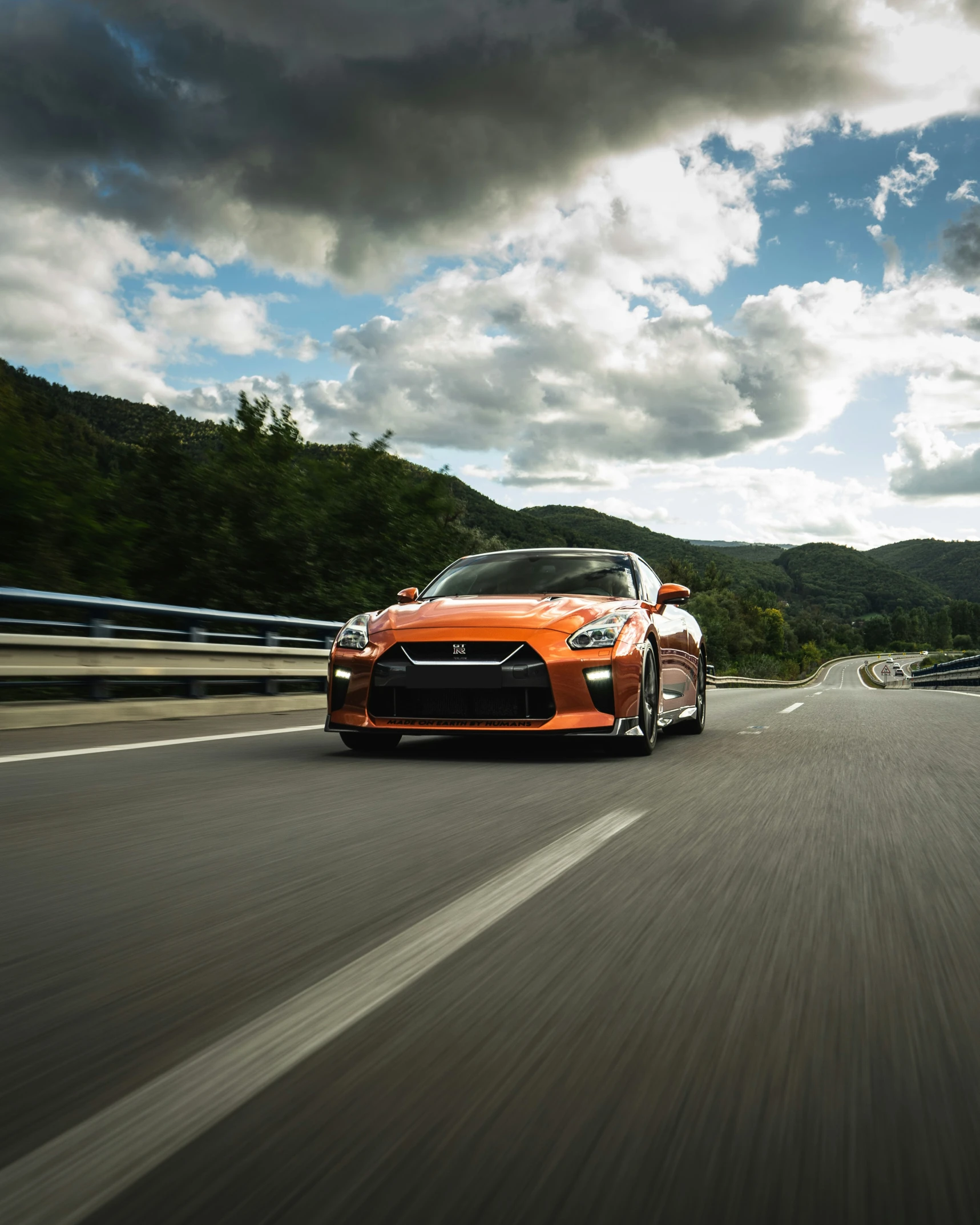 a car driving down the road near mountains