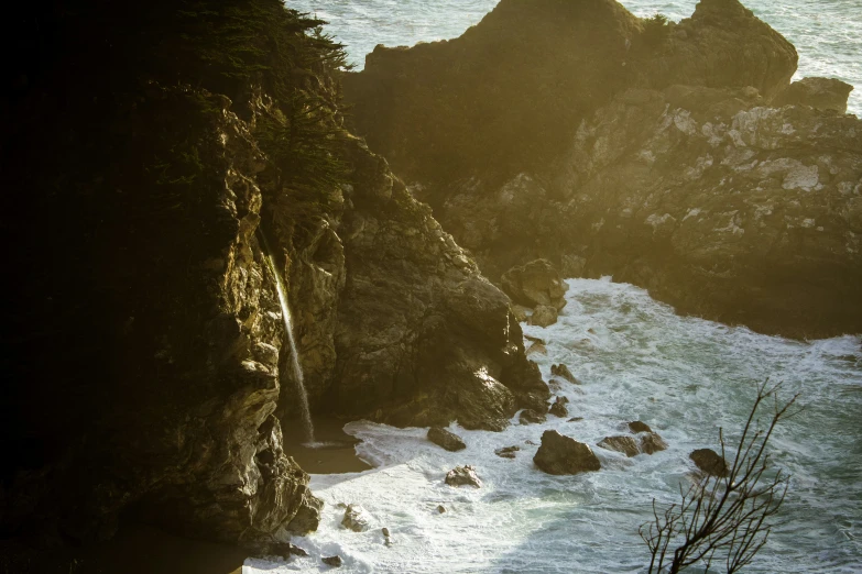 people are surfing and swimming in the ocean near some rocks