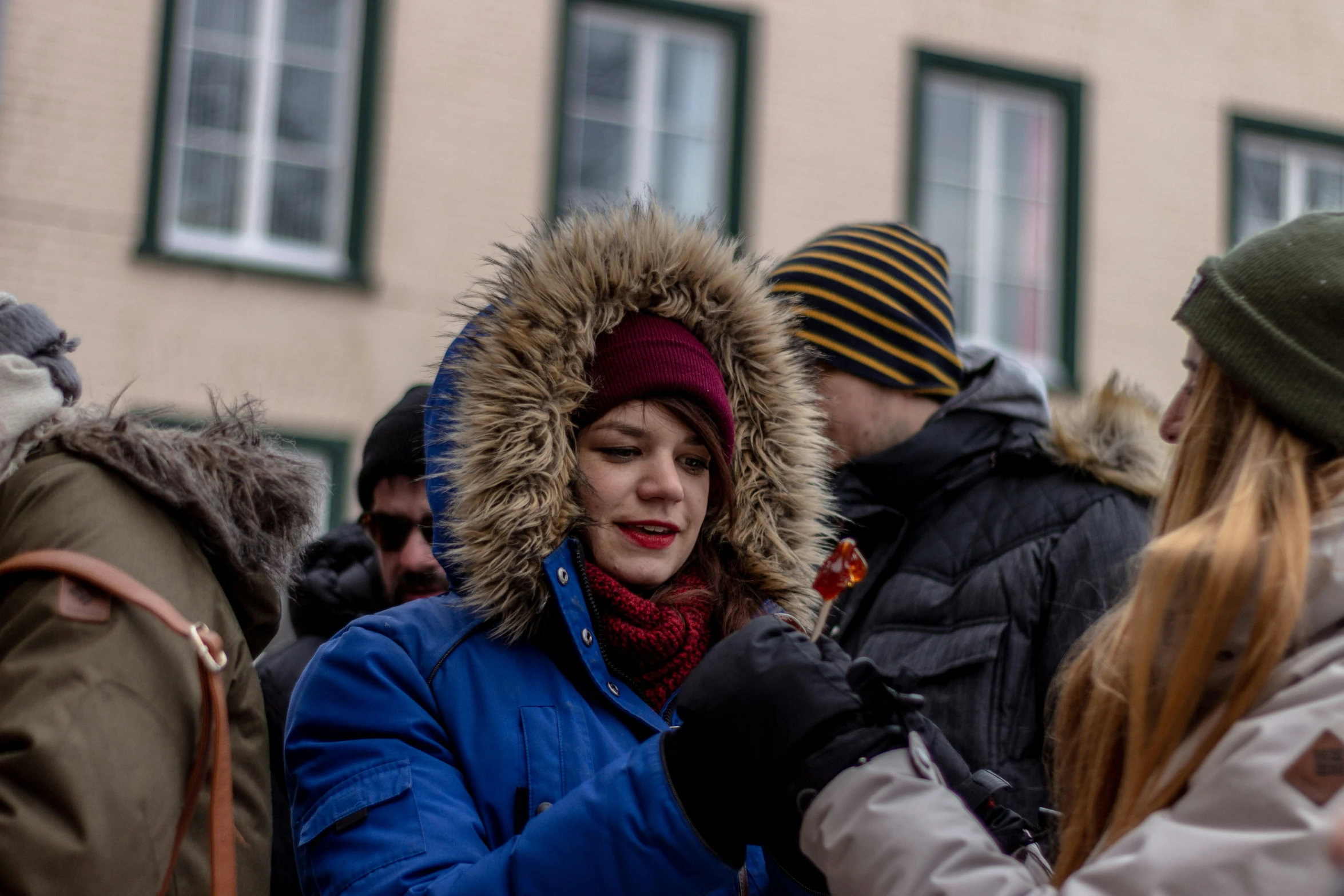 woman in winter clothes talking to another person