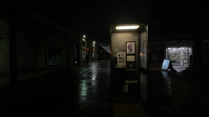 a dimly lit night city street with an open door