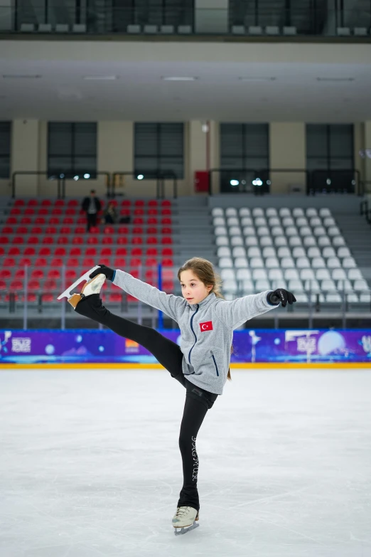 a girl on an ice skates in front of an arena