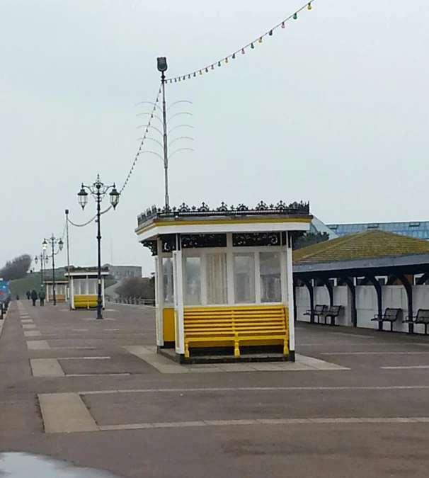 a couple of yellow benches and a few white buildings