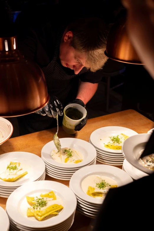 a chef is preparing food on white plates