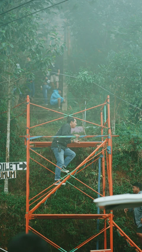 a guy riding a ski lift in the woods